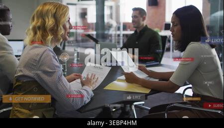 Examen des documents, équipe en tenue de travail assise à la table de réunion avec un ordinateur portable et des superpositions numériques Banque D'Images