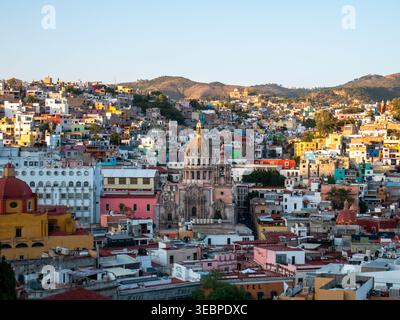 Belle vue panoramique à l'heure d'or du paysage de la ville de Guanajuato avec des maisons colorées vibrantes et l'emblématique dôme historique de la cathédrale rose Banque D'Images