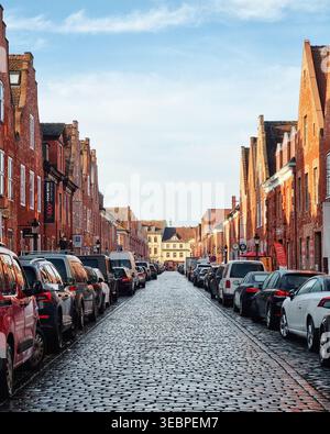 Rue pavée dans le quartier hollandais. Vue panoramique sur le Holländisches Viertel avec des maisons en briques rouges avec des toits à pignons le long de la route pavée. Banque D'Images