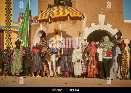 Zaria City, Nigeria - 22 mars 2026 : vue d'une procession vibrante avec une figure royale sur un cheval sous un parapluie frappant, passant un teint de terre Banque D'Images