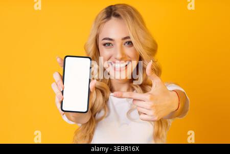 Une femme se tient dans un studio avec un fond jaune vif Banque D'Images