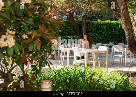 Terrasse de jardin salle à manger à Antibes, France avec chaises blanches et arbres Banque D'Images