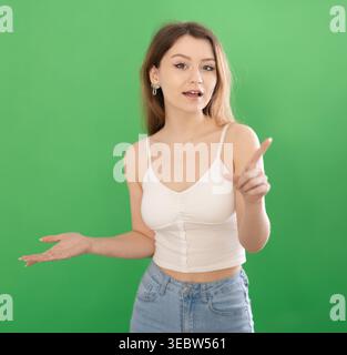 Jeune femme parlant devant un écran vert Banque D'Images