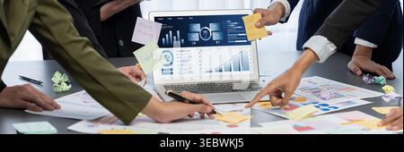 L'équipe d'analystes utilise le pense-bête pour le brainstorming créatif et analytique pour l'idée commerciale avec le tableau de bord des données de veille stratégique sur l'écran d'un ordinateur portable. Analyse des données financières Banque D'Images