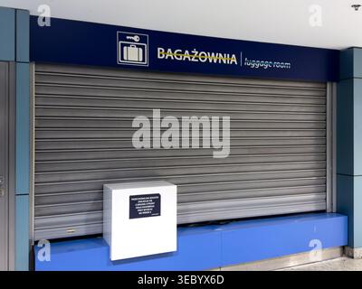 Une salle à bagages fermée avec une porte à roulettes en métal et une signalisation indiquant qu'il s'agit d'une zone de stockage des bagages, fermée pour le service Banque D'Images