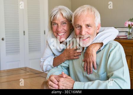 Vieillissement en bonne santé et sécurité à long terme, un couple de personnes âgées heureux embrasse chaleureusement, symbolisant la confiance et l'affection dans leurs années d'or. Banque D'Images