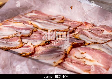 Bacon grillé en tranches détaillées sur papier. Aliments traditionnels à base de viande de porc en gros plan Banque D'Images