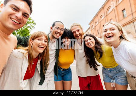 Jeunes amis divers souriant et se liant à l'extérieur Banque D'Images