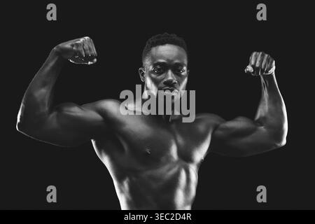 Strong Man fléchit les muscles dans un cadre noir et blanc dramatique mettant en valeur Fitness et détermination Banque D'Images