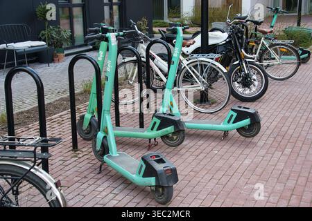 Scooters et vélos électriques verts partagés en environnement urbain Banque D'Images