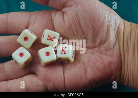 Un homme tenant une paire de dés de poker, espérant une pause chanceuse à la table. Banque D'Images