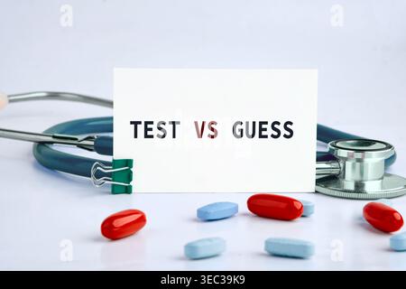 Un TEST de lecture de carte blanche VS GUESS se tient bien en évidence au milieu des pilules médicales et d'un stéthoscope sur une surface propre. Banque D'Images