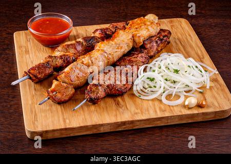 Brochettes de porc barbecue grillées sur une planche à découper en bois ***photographie originale du contributeur, modifiée à l'aide d'outils IA ** Banque D'Images