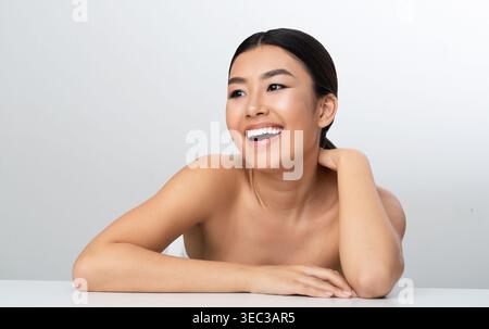 Sourire jeune femme posant naturellement sur un fond Uni dans un cadre détendu Banque D'Images