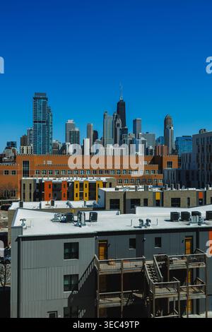 City skyline montre de hauts bâtiments et des appartements sous un ciel bleu clair. La vue comprend une architecture moderne et des couleurs vibrantes sur les structures inférieures. Banque D'Images