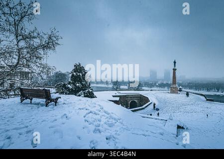 24 décembre 2024, Belgrade, Serbie : Parc de la forteresse de Kalemegdan couvert de neige fraîche, avec le monument de Pobednik et la ligne d'horizon de la ville sous une victoire brumeuse Banque D'Images
