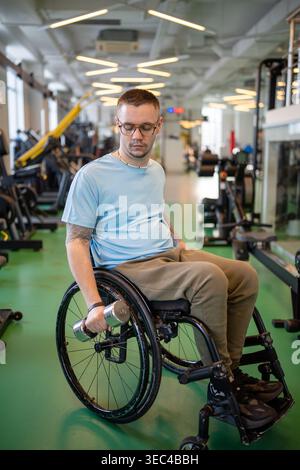 Athlète masculin handicapé travaillant avec haltère, faisant de l'exercice d'haltérophilie pour la force du bras. Banque D'Images