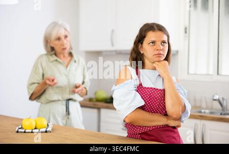 Femme âgée qui fait une petite cuisine dans une cuisine moderne Banque D'Images