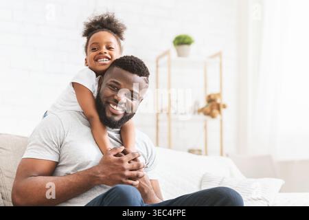 Sourire Père et fille profiter de temps de qualité ensemble à la maison un jour ensoleillé Banque D'Images