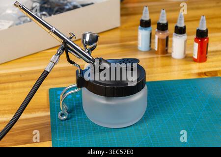 Gros plan du kit de voiture modèle non peint avec outils et peinture sur tapis de coupe – espace de travail de modélisation de l'échelle Banque D'Images
