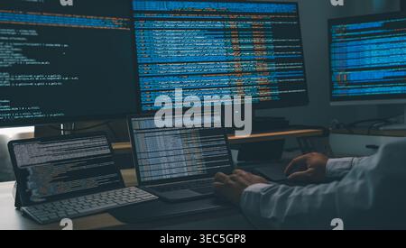 Homme utilisant un chatbot IA tout en codant sur un poste de travail multi-moniteur avec ordinateur portable et écrans affichant des scripts, montrant le développement de logiciels, l'automatisation Banque D'Images