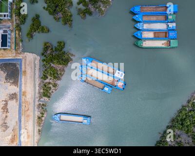 Vue aérienne de haut en bas des barges bleues amarrées le long de la rive. Banque D'Images