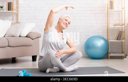 Femme âgée active faisant des exercices à la maison Banque D'Images