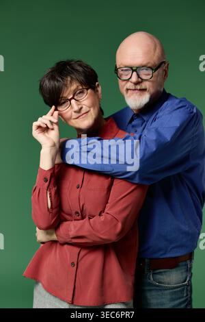 Un joyeux couple senior partage un moment d'amour, entouré de verdure. Banque D'Images