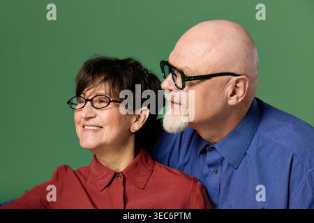 Un couple de seniors profite d’un moment tendre ensemble, souriant chaleureusement et embrassant leur amour. Banque D'Images