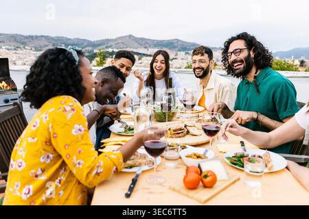 Amis divers appréciant la fête barbecue d'été sur la terrasse Banque D'Images