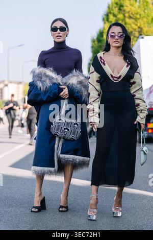 Milan, Italie - 24.2021 : Giorgia Tordini porte un manteau long avec bordure en fourrure, col roulé violet, sandales à talons, sac à main Prada, lunettes de soleil, Amina Muaddi porte une robe, des lunettes de soleil, des sandales à plateforme argentée Banque D'Images