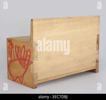 Banc en bois d'un ensemble de meubles de poupée. Banc en bois avec un caisson fermé par un rabat formant siège. Décoration peinte avec des silhouettes animales schématiques - un chat tabby sur le dossier et des poulets sur les côtés et la paroi avant de la boîte. Jouet, hauteur 11,5 cm, largeur 17,0 cm, profondeur 8,0 cm. Fait 1947–1948, Zakopane. Créateur : Kenar, Antoni 1906–1959 ; conçu à l'École secondaire d'État des Beaux-Arts de Zakopane et produit par le Bureau de la supervision esthétique de la production 1947–1949., Une boîte rectangulaire en bois avec une finition de grain de bois beige pâle repose sur un fond gris clair, montrant a Banque D'Images