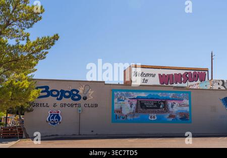 Bienvenue à Winslow Arizona peintures murales et panneau du grill et club sportif Bojos avec logo de la route 66 sur le mur du bâtiment sous un ciel bleu en journée Banque D'Images
