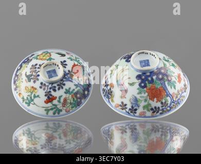 Bol avec couvercle, chinois ; dynastie Qing, période Qianlong 1736–1795 ; porcelaine colorée; décoration : dans un jardin serti de rochers, arbres, pivoines, magnolias, chrysanthèmes deux faisans et un papillon ; signé ; navire ; hauteur 7,5 cm, diamètre 11,7 cm, poids 0,2 kg., deux petits bols en porcelaine sont montrés à l'envers sur une surface réfléchissante lisse, chacun décoré de motifs floraux et d'oiseaux. Les bols sont principalement blancs avec des motifs peints complexes dans une palette qui comprend bleu, vert, rouge, orange, rose, accents jaunes et dorés. Un bol est orné d'une fleur rouge orangée proéminente et d'un vert feuillu Banque D'Images