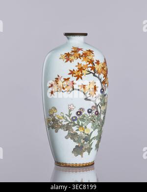 Vase, émail cloisonné, vase allongé ovoïde avec un bec étroit ; décoration : chrysanthèmes, érables et ornements de plantes iconographie des fleurs ; art japonais, Meiji 1868–1912 / Taishō 1912–1926, CA. 1910–1920 ; fabricant, Nagoya, Japon; hauteur 12,4 cm, diamètre 16,3 cm., Un grand vase élancé avec un fond blanc bleuâtre pâle avec des branches peintes avec des feuilles d'automne dans les tons orange, rouge et jaune, et une grappe inférieure de fleurs et de feuillage en vert avec des fleurs en violet, jaune et rose pâle ; le vase a un col étroit avec un bord brun foncé et une bande décorative près de la base en brun Banque D'Images