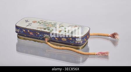 Boîte aux lettres fubako avec couvercle, art japonais, culture japonaise, Meiji 1868–1912, boîte en émail cloisonné avec oiseaux et chrysanthèmes, fin du XIXe siècle période Meiji, Japon ; récipient ; hauteur 4,6 cm, largeur 23,0 cm, profondeur 8,8 cm., Une boîte décorative rectangulaire avec des coins arrondis repose sur une surface réfléchissante, montrant un reflet miroir en dessous ; la boîte a une surface supérieure pâle peinte avec des motifs floraux et quelques petits oiseaux, avec des couleurs telles que blanc, vert, orange, rose, jaune, et bleu, et une bande bleue autour des côtés décorée de motifs floraux et de volutes en or, rose, blanc, et Banque D'Images