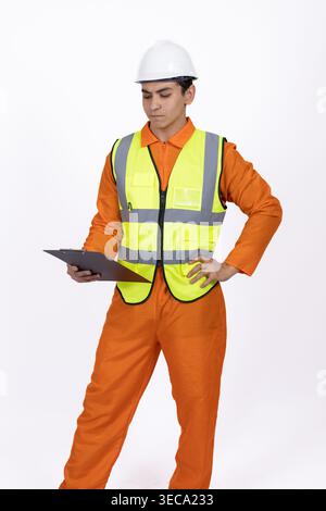 Travailleur en uniforme orange et casque de sécurité avec tablette Banque D'Images