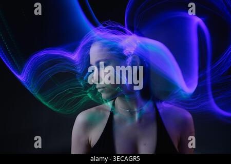 Portrait abstrait avec des ondes violettes et vertes symbolisant l’intelligence artificielle, les flux de données et le traitement mental. Banque D'Images