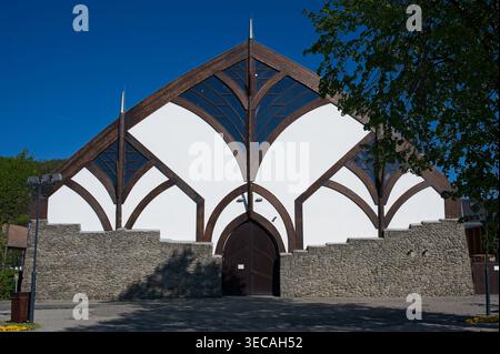 Visegrad, Hongrie - 18 avril 2026 : vue panoramique sur la salle de sport locale, un bâtiment organique avec façade en bois et pierre dans le style d'Imre Makovecz. Banque D'Images