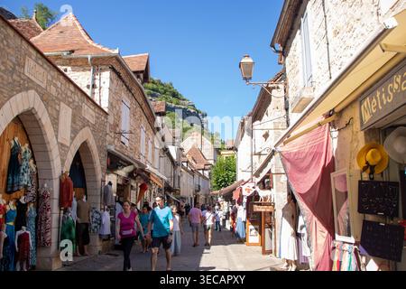 ROCAMADOUR, FRANCE, 3 AOÛT 2025 : les touristes se promènent dans la rue principale étroite et ensoleillée du village médiéval de Rocamadour. L'image capt Banque D'Images