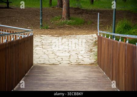 Pont en bois menant au sentier en pierre dans le parc Banque D'Images