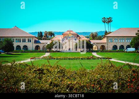 Palo Alto, Californie, États-Unis – 17 avril 2026 : vue symétrique de l’église Stanford Memorial et du quad principal avec pelouse et fleurs. Banque D'Images
