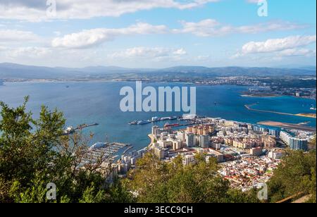 Une vue aérienne panoramique de Gibraltar, mettant en valeur le paysage urbain, le port et la marina le long de la côte. L'image capture les bâtiments modernes, les navires doc Banque D'Images