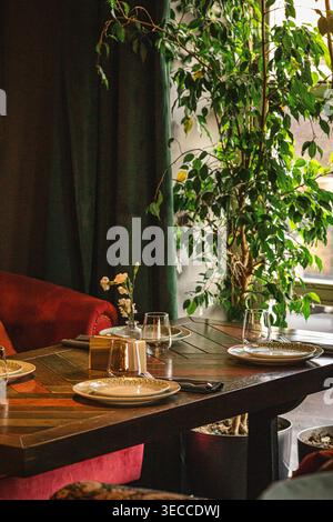 Intérieur de restaurant confortable avec table et plantes Banque D'Images