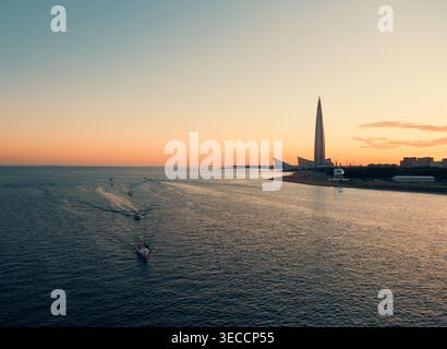 Saint-Pétersbourg, Russie - 01 juillet 2021 : la vue aérienne capture les bateaux naviguant dans les eaux de la baie de Neva sous un ciel de coucher de soleil coloré près de Lakhta Center Saint Banque D'Images