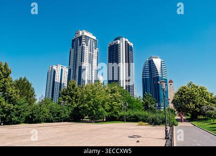 Grozny, Russie - 30 juillet 2021 : les tours modernes de la ville de Grozny s'élèvent dans un ciel bleu vif au-dessus d'un parc urbain verdoyant Banque D'Images