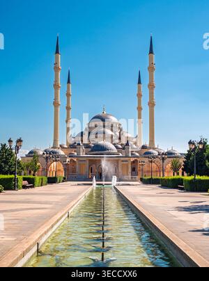 Grozny, Russie - 30 juillet 2021 : majestueuse mosquée Akhmad Kadyrov et sa piscine réfléchissante sous un ciel bleu clair Banque D'Images