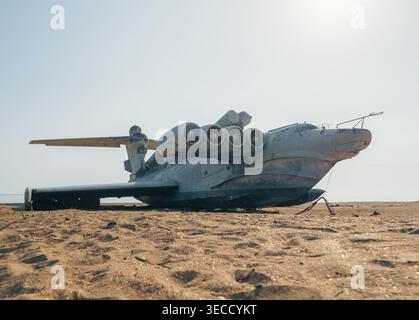 Ekranoplan abandonné de classe LUN sur une plage déserte près de la mer Caspienne sous un ciel bleu clair Banque D'Images
