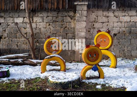 Figurines animales peintes à la main à partir de pneus recyclés sur une aire de jeux recouverte de neige. Nijni Novgorod, Russie. Banque D'Images