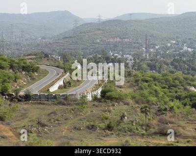 La route serpentine serpente à travers des collines verdoyantes dans la campagne rurale paisible, Hogenakkal, Tamil Nadu, Inde Banque D'Images